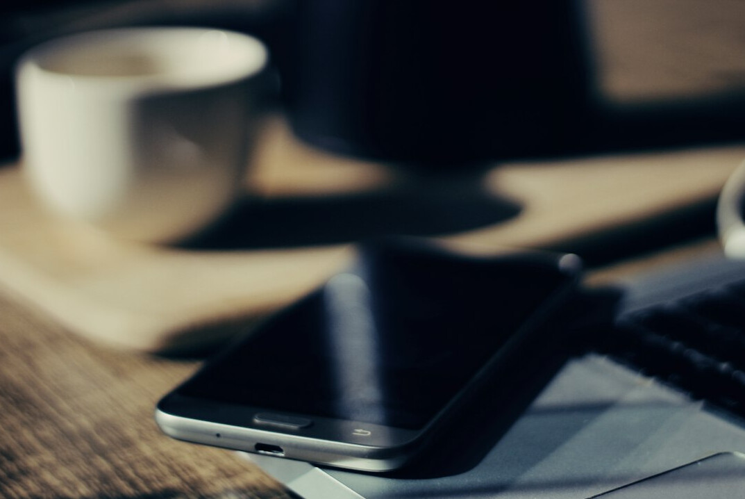 Desk with notebook phone and coffee ready for contact